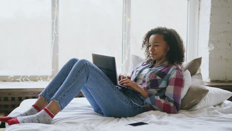 teenage girl using laptop in bedroom
