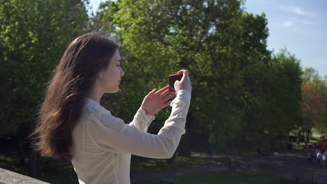 bonita mujer italiana turista tomando fotografías de un parque en wimbledon londres