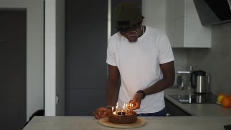 Young-black-man-celebrating-his-birthday-at-home,-lighting-candles