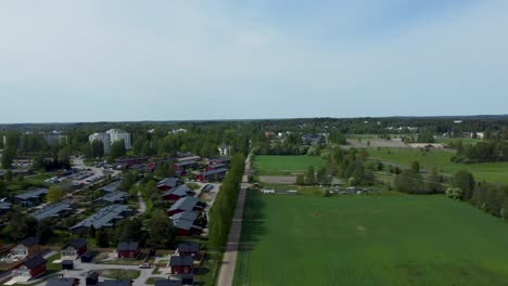 The-city-is-nestled-amidst-a-vibrant-green-forest,-and-a-drone-hovers-above,-capturing-the-fusion-of-nature's-lush-canopy-and-the-dynamic-urban-setting