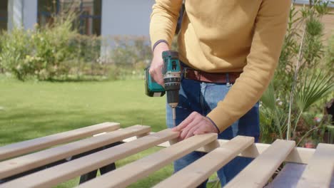 the worker screws several wooden boards together