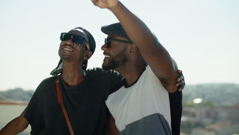 happy afro-american gay couple hugging and looking at sky