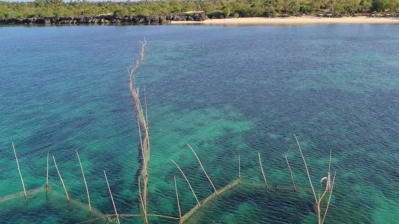 crystal clear water, net and fishing cage, and beach of tropical Boracay. Aerial