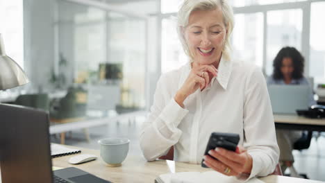 smiling senior businesswoman using smartphone in modern office