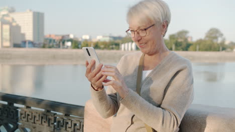 senior woman having a video call outdoors
