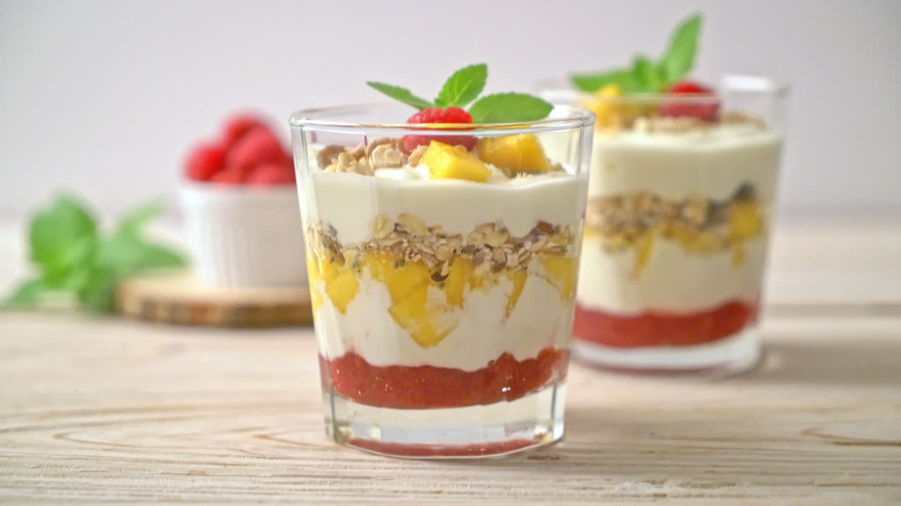 mango fresco casero y frambuesa fresca con yogur y granola - estilo de comida saludable