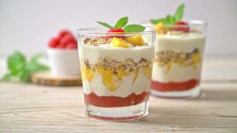 homemade fresh mango and fresh raspberry with yogurt and granola - healthy food style