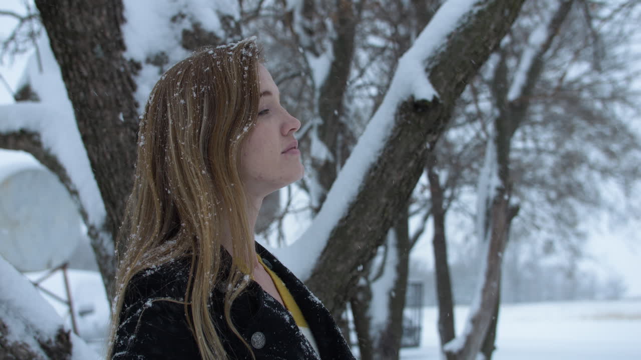 mujer feliz afuera en cámara lenta nieve de invierno como copos de nieve caen en cámara lenta cinematográfica