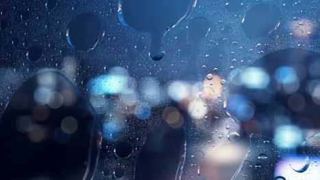 water droplets on glass with city lights