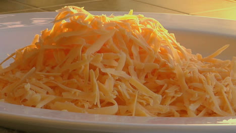 un movimiento lento hacia el queso rallado sentado sobre humeantes huevos revueltos