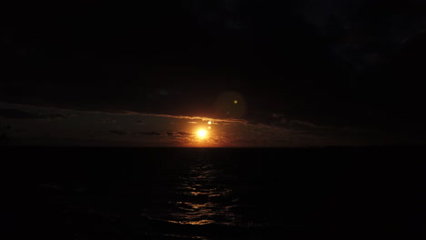 ominous clouds hanging like a black shroud over a moody sunset on lake ontario, slow motion wide shot
