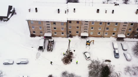 team of workers connect wires on freshly built power line pole, aerial view