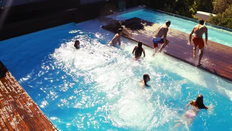 happy friends jumping in the pool