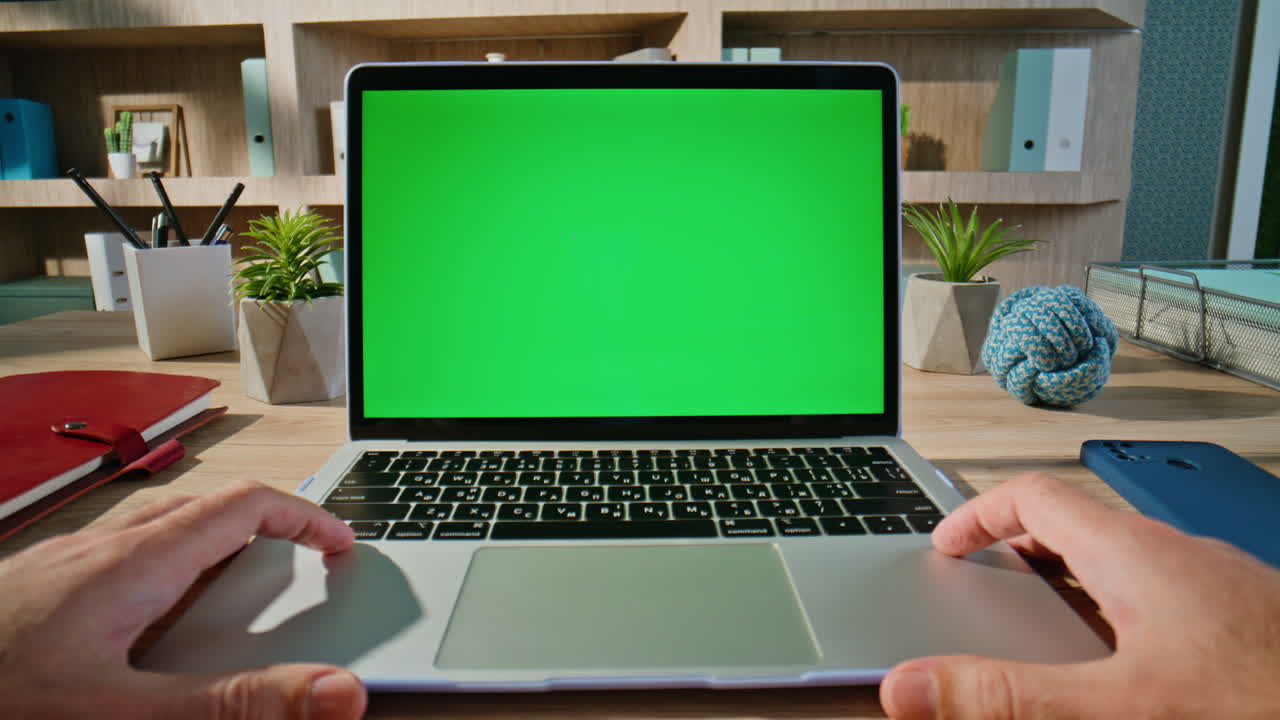 Student browsing lesson green screen laptop in organized workspace closeup