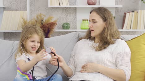 the mother is playing the doctor game with her daughter who wants to be a doctor.