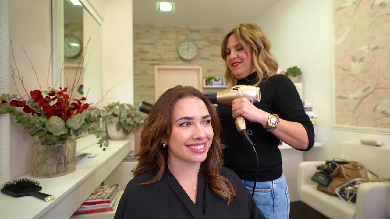 Hairdresser Blow Drying Client's Hair in a Modern Salon
