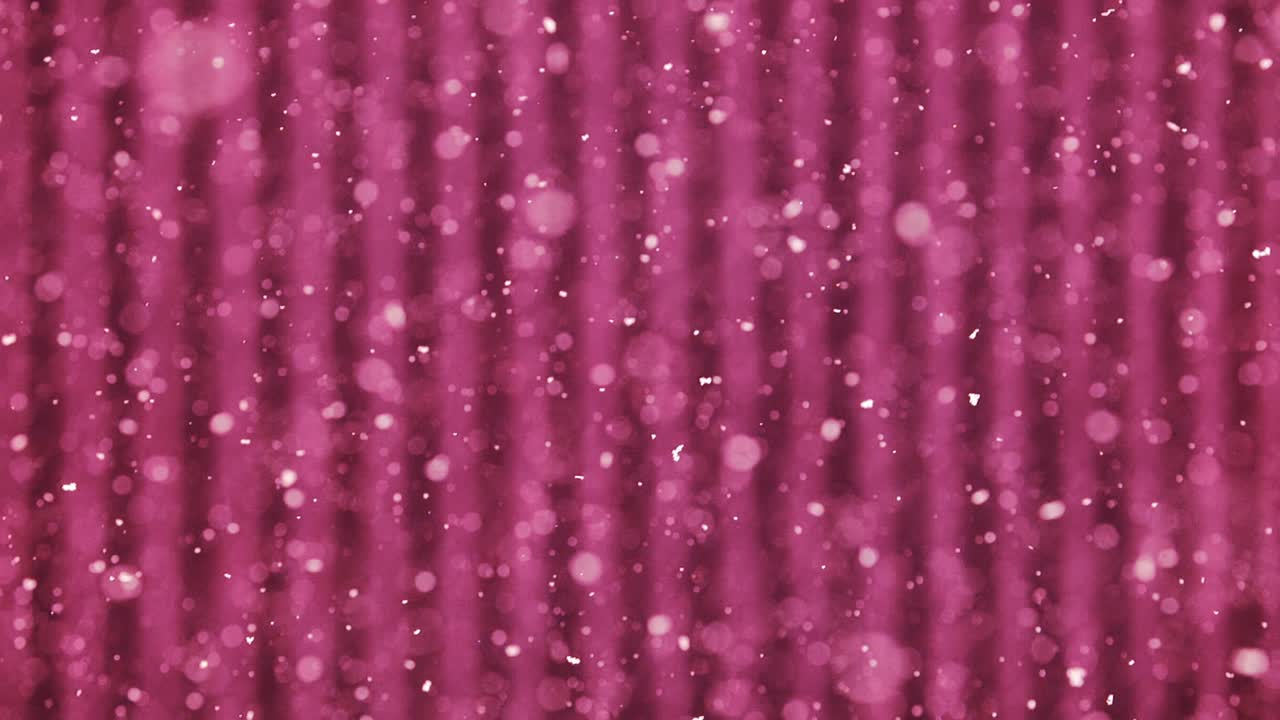 Soft pink background with floating snow particles and gentle glowing bokeh