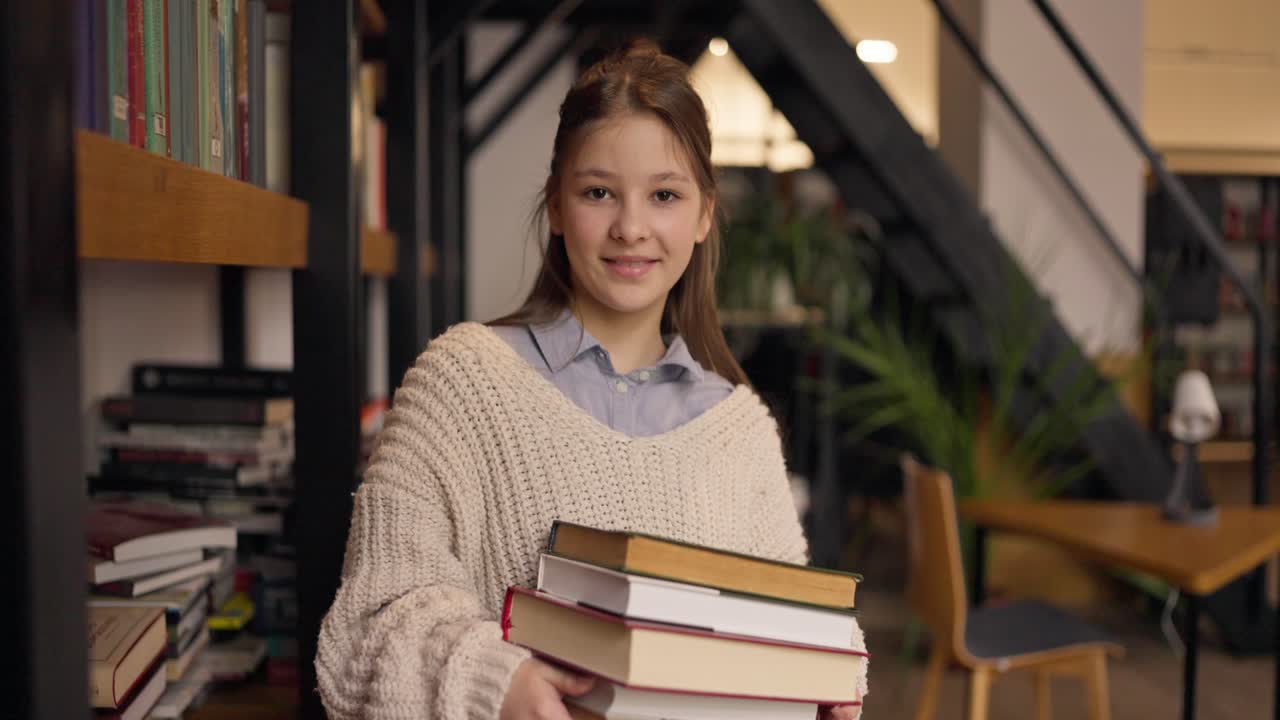 Adolescente con libri in una caffetteria della biblioteca