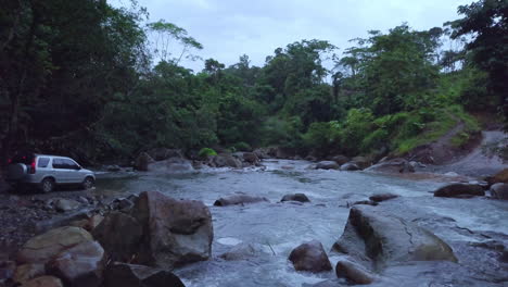 aerial view of a suv crossing a small river
