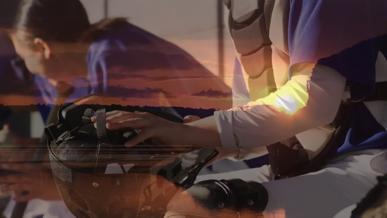 Animation of sunset over diverse male and female football team preparing for match
