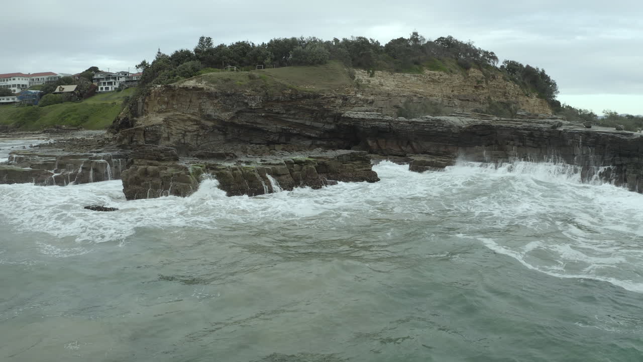 4k Drone shot of ocean sea water crashing on rocks at Yamba, Australia