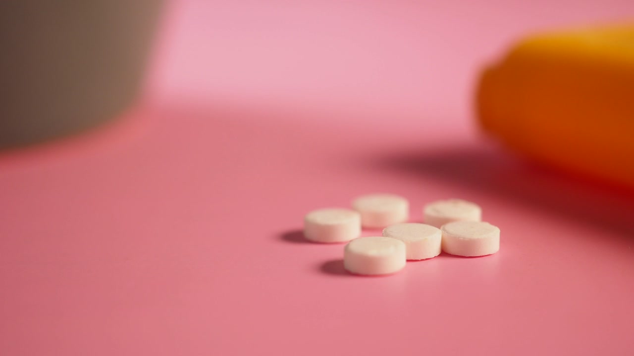 Close-up of White Pills on a Pink Background