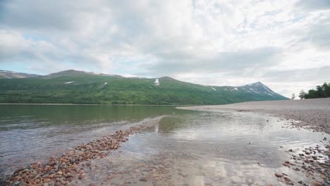 agua clara del río que fluye a orillas del río con guijarros en noruega