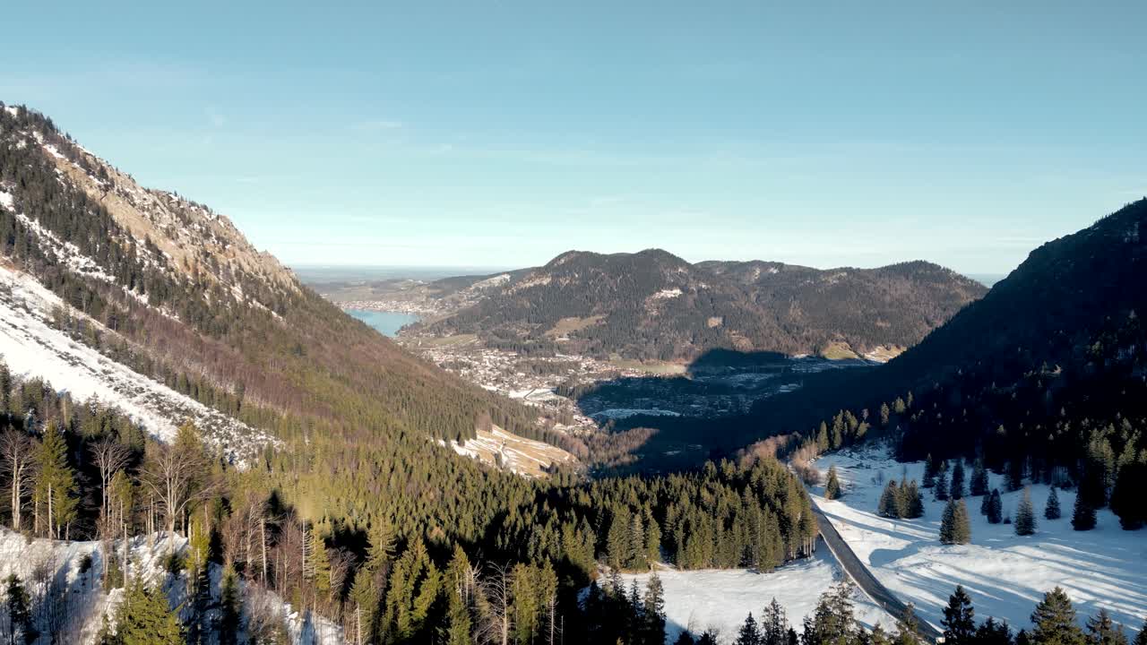 impresionante vista aérea desde un avión no tripulado: paso de montaña cubierto de nieve, vista panorámica del schliersee en alemania, paisaje de los alpes bávaros con carretera y lago de montaña lejano en la temporada de invierno