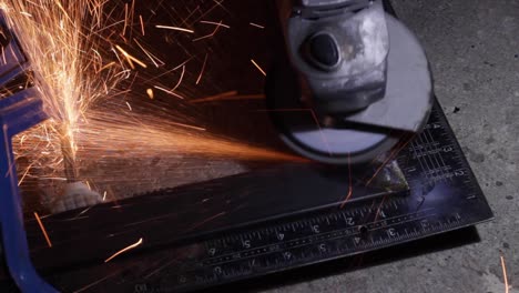 toques finales con una amoladora de sierra a un marco de metal en el taller