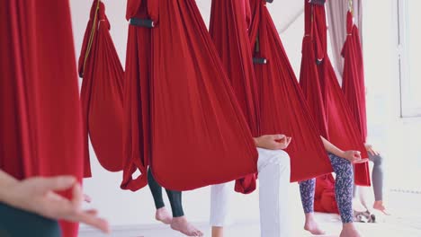 women sit in hammocks with fingers in mudra position