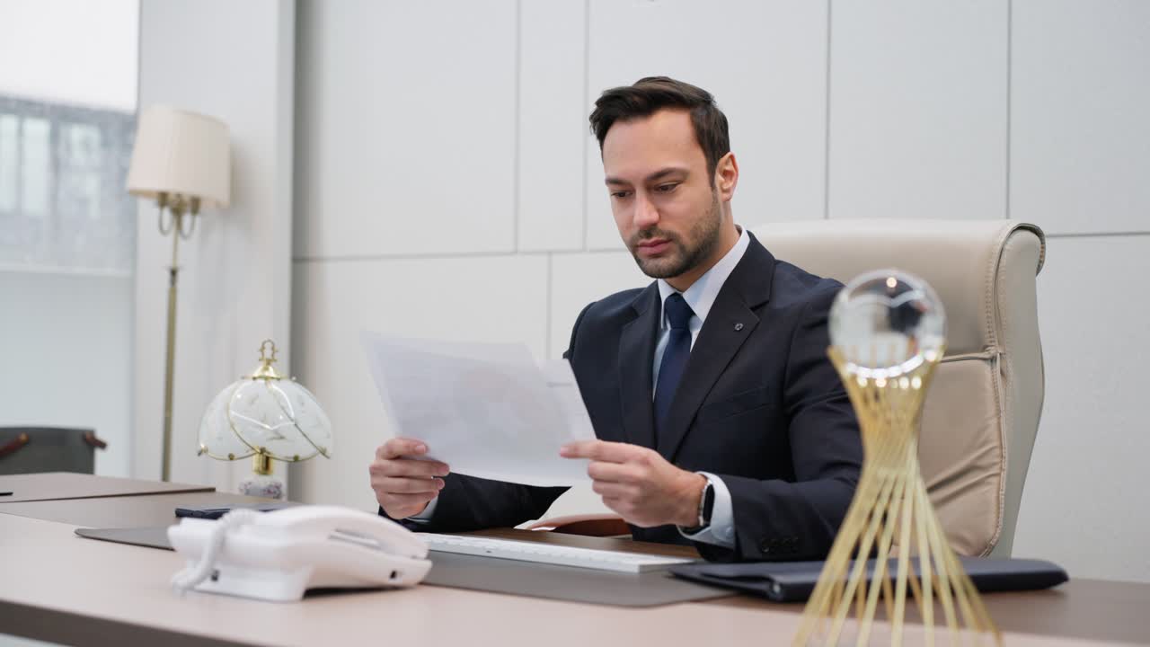 A corporate executive man sitting in a modern office, thoughtfully reviewing a document, exuding focus and a calm, serious demeanor