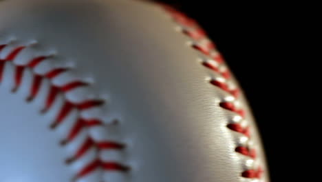 baseball ball isolated on black background. red seam on white ball