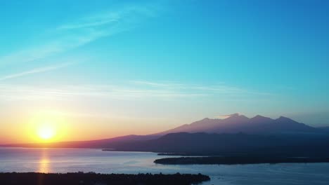 beautiful golden sunrise during an early morning over mountains and reflecting into the water