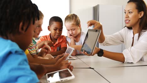 maestro enseñando a un niño en una tableta digital en la biblioteca