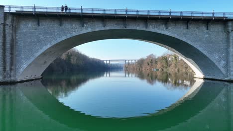 a wonderful aerial view over the rhine under a bridge, past a village called eglisau in switzerland