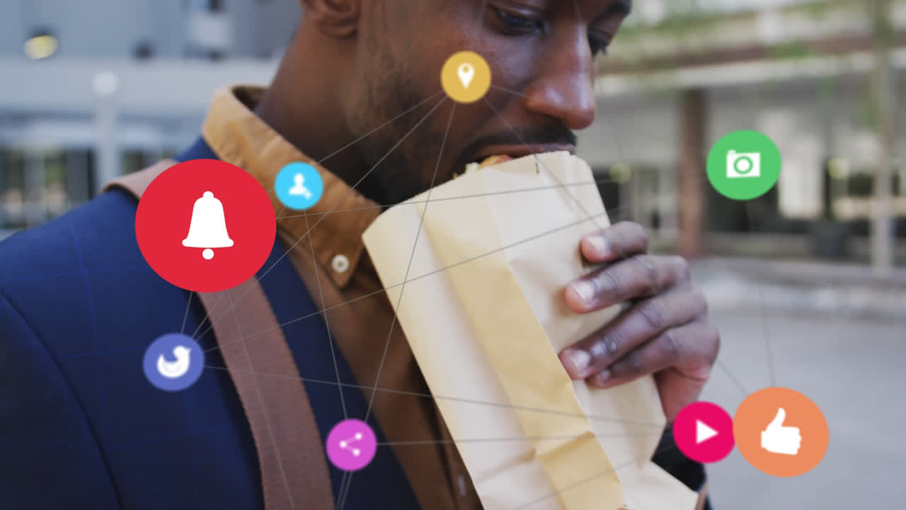 Network of digital icons against african american man having a snack on the street