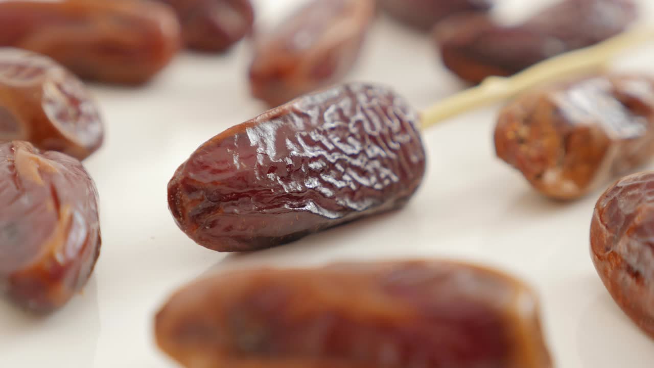Delicious palm dates  exotic fruit on white background slow panning 4K 2160p UltraHD footage - Phoenix dactylifera fruit on white slow pan  close-up 4K 3840X2160 UHD video