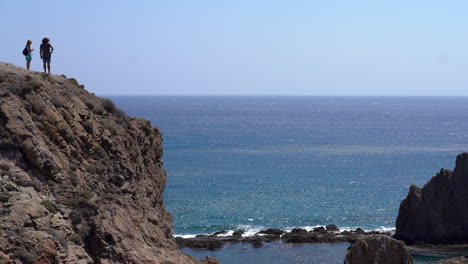 Couple-on-edge-of-cliff-at-Las-Sirenas,-Cabo-De-Gata,-Almeria
