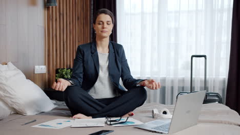businesswoman meditating in hotel room