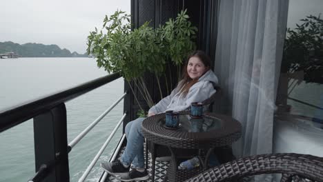 woman in her 30s sitting on the balcony of a cruise ship