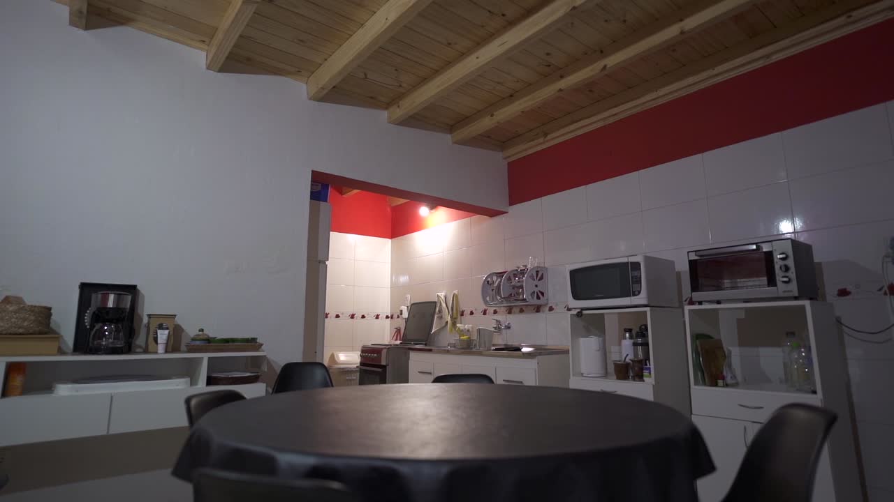 Bright and Cozy Interior View of a Home Featuring a Dining Area Connected to the Kitchen with Clean Surfaces and Functional Appliances Throughout The Space slow motion reveal