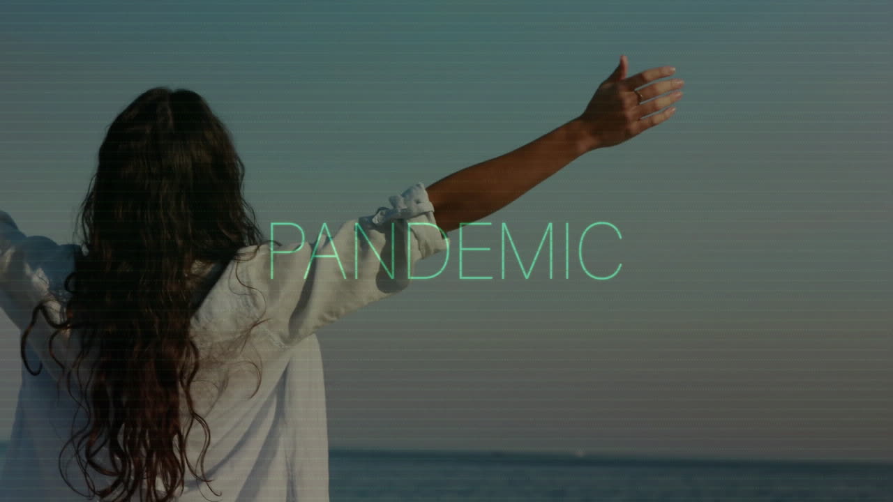 Di tepi laut, seseorang dengan tangan terentang, dengan animasi overlay teks Pandemic