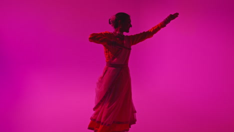 spinning female kathak dancer performing dance wearing traditional indian dress against purple background 2