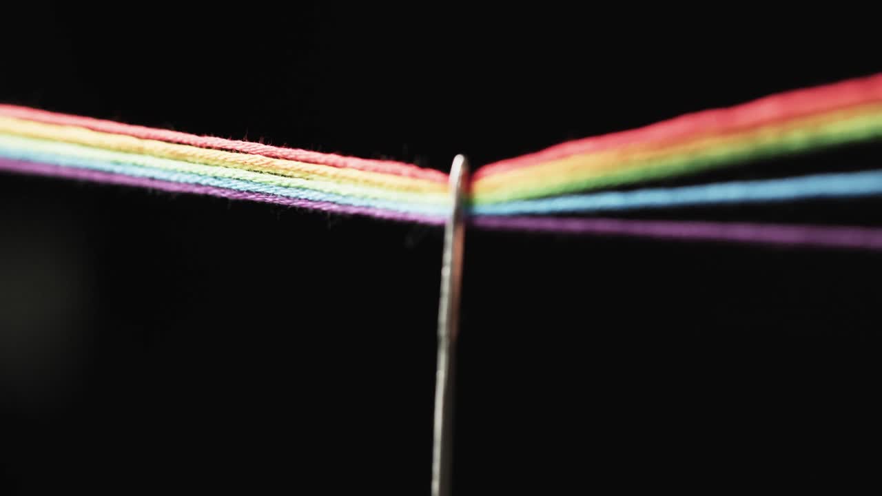 검은색 배경에 복사 공간을 가진 바늘을 통과하는 무지개 색의 나선의 마이크로의 비디오