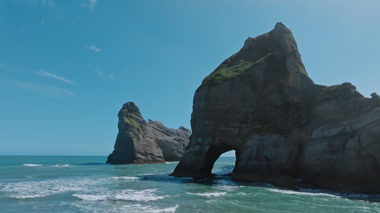 뉴질랜드의 남쪽 섬인 케이프 아우데웰 (cape farewell) 에 있는 태즈만 해의 거친 바위 어리와 함께 멀리 떨어진 야생 해안 풍경의 공중 풍경.