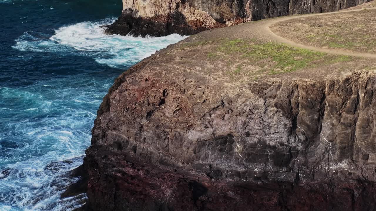 Le onde si infrangono contro scogliere rocciose a Lanzarote, Spagna, a mezzogiorno