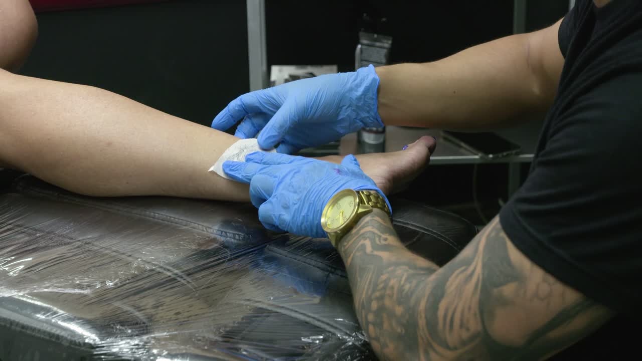 문신 그림 이 있는 종이 한 장 이 고객 의 다리 에 놓여 있다