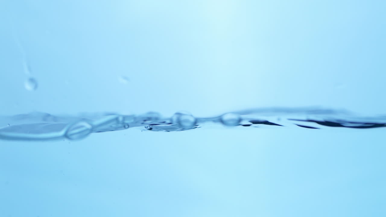 물의 부드러운 파동이 표면을 가로질러 파동하여 자연에서 순수한 액체의 부드럽고 원활한 움직임을 강조합니다.