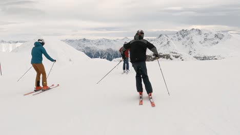 cinematic show skiing with 3 ski athletes in a ski resort high up in the mountains with amazing panorama view over the snowy mountain tops