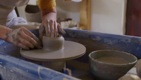 young female potter working in her studio